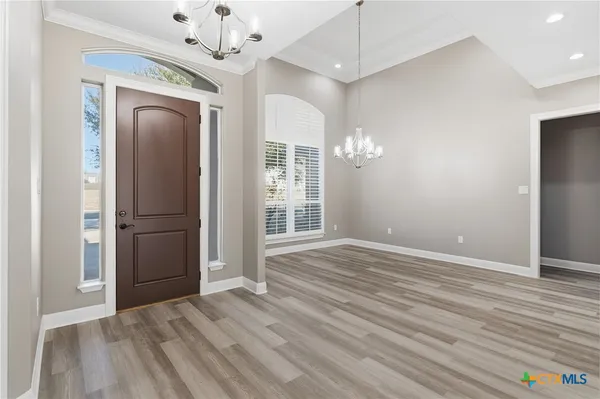 a view of a kitchen with kitchen island a sink wooden floor and a large window