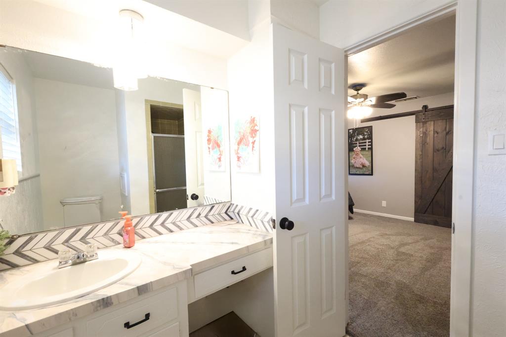 1300 Hillcrest Road Coleman, TX 76834 - Photo 26 of 35 a bathroom with a granite countertop sink and a mirror