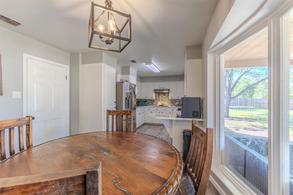 1300 Hillcrest Road Coleman, TX 76834 - Photo 5 of 35 a dining room with stainless steel appliances granite countertop a dining table chairs and a chandelier