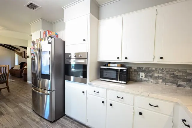 a kitchen with stainless steel appliances a refrigerator sink and microwave