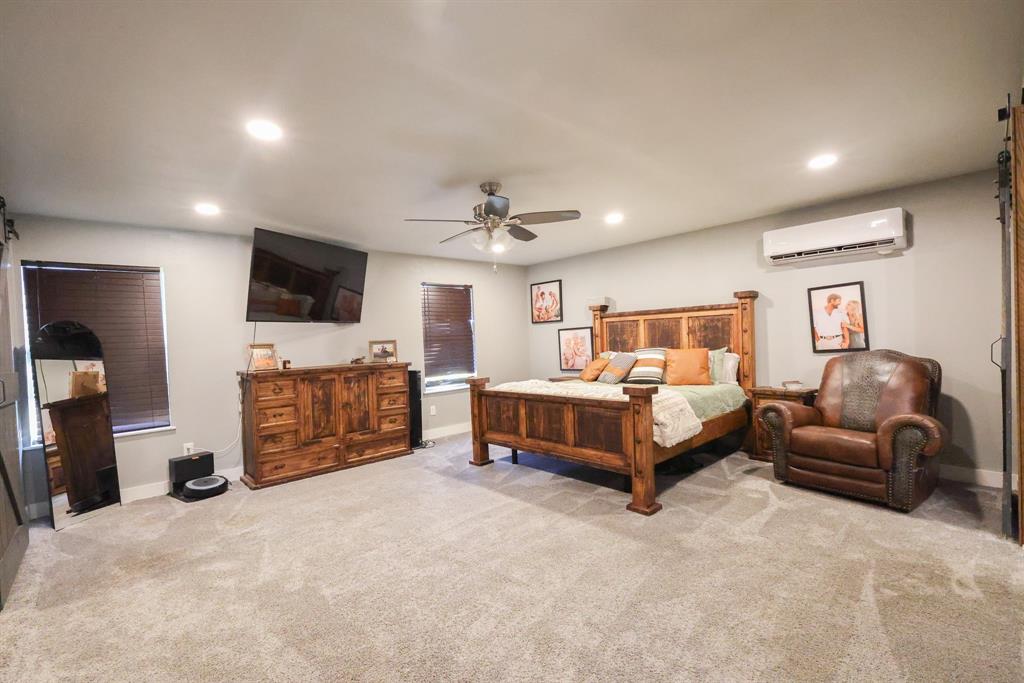 1300 Hillcrest Road Coleman, TX 76834 - Photo 10 of 35 a spacious bedroom with a bed and flat screen tv