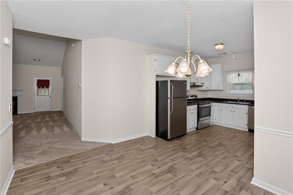 181 Windsor Circle Stockbridge, GA 30281 - Photo 20 of 49 a kitchen with stainless steel appliances granite countertop a sink cabinets and wooden floor