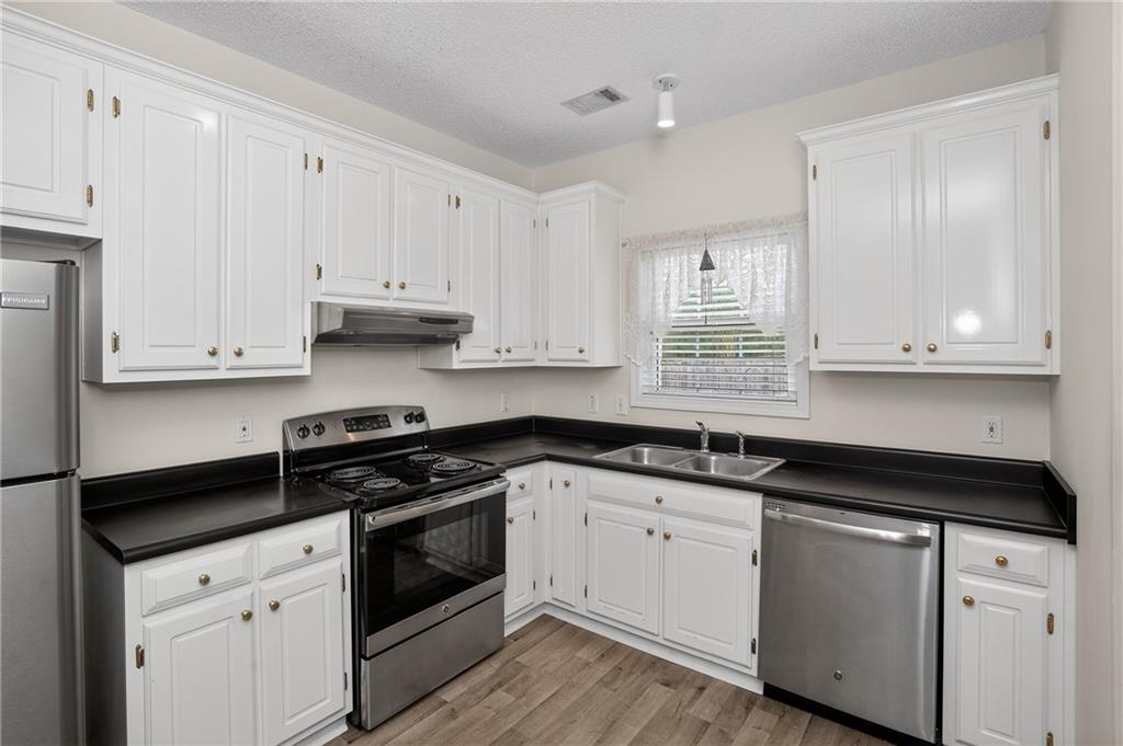 181 Windsor Circle Stockbridge, GA 30281 - Photo 22 of 49 a kitchen with granite countertop white cabinets and black appliances