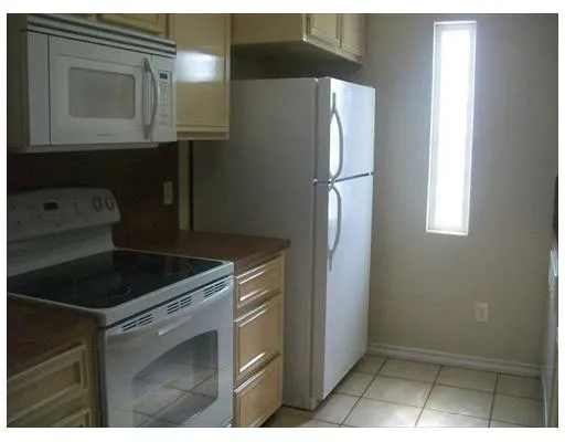 a kitchen with a refrigerator stove and cabinets