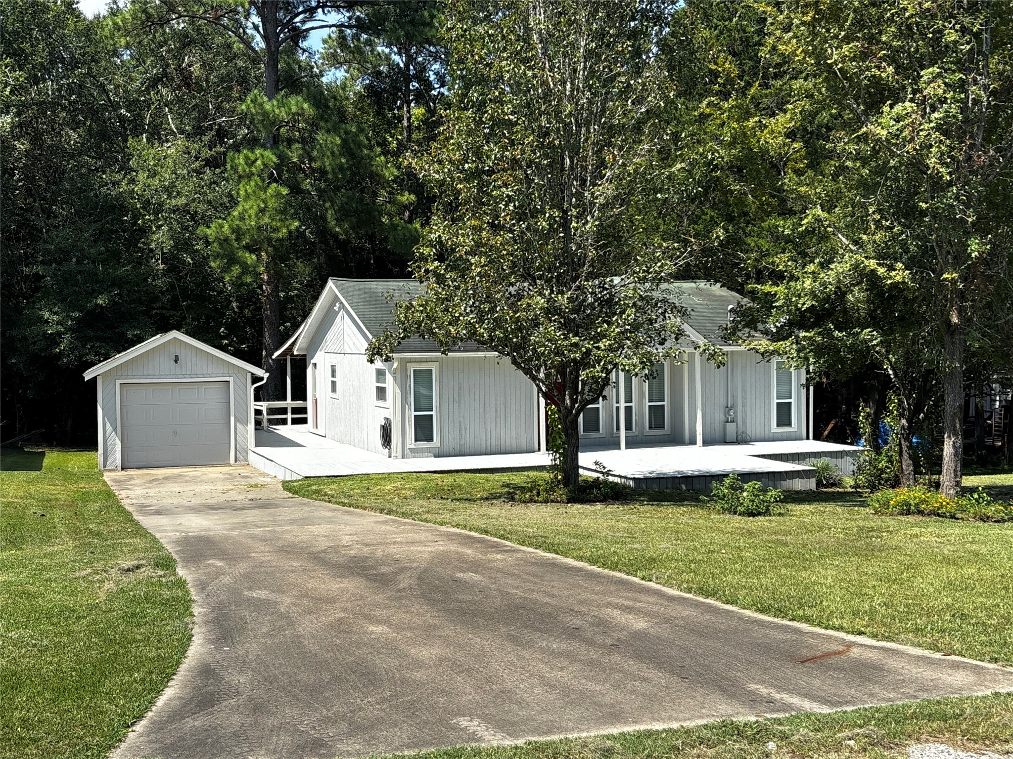 90 Cove Road Coldspring, TX 77331 - Photo 3 of 24 a front view of a house with a garden and trees