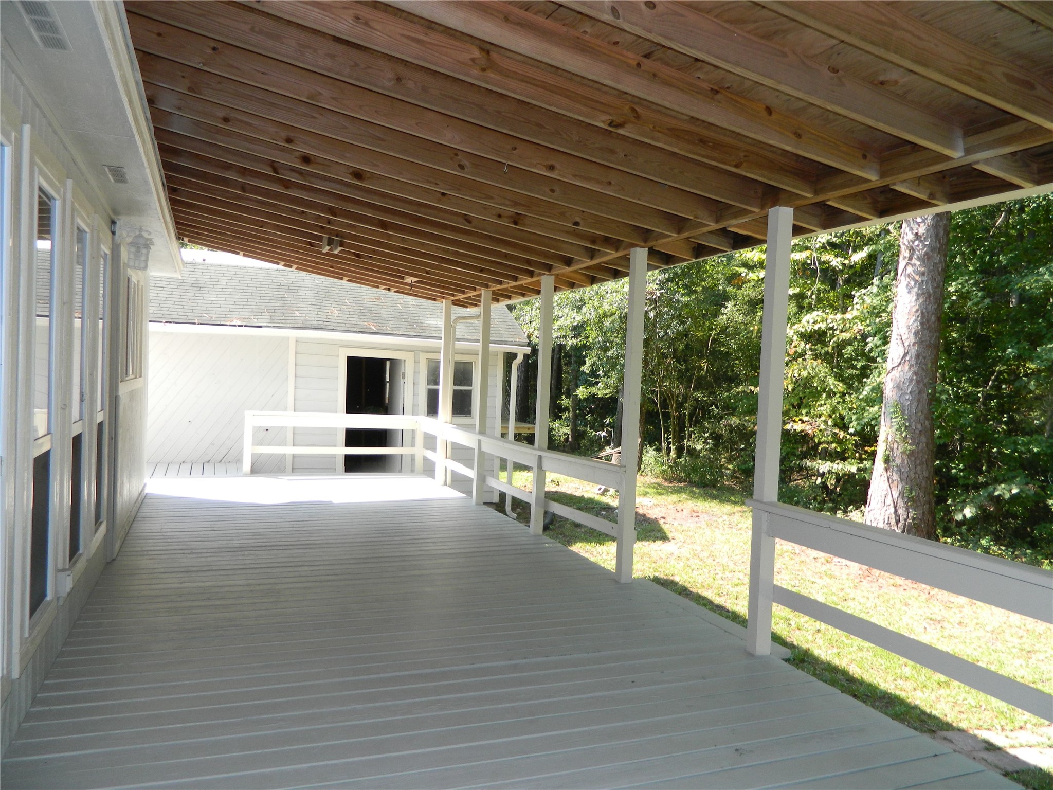 90 Cove Road Coldspring, TX 77331 - Photo 8 of 24 a view of a porch with wooden floor and roof with a garden