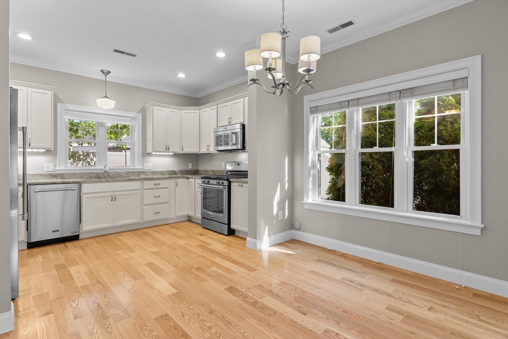 4 Emerald Way, Unit 4 Salisbury, MA 01952 - Photo 14 of 40 a large white kitchen with a window wooden floor and stainless steel appliances