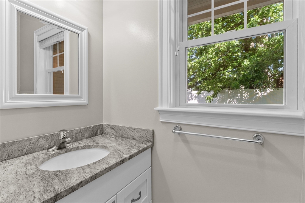 4 Emerald Way, Unit 4 Salisbury, MA 01952 - Photo 24 of 40 a bathroom with a granite countertop sink and a mirror