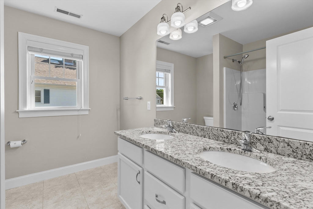 4 Emerald Way, Unit 4 Salisbury, MA 01952 - Photo 35 of 40 a bathroom with a granite countertop sink and a mirror
