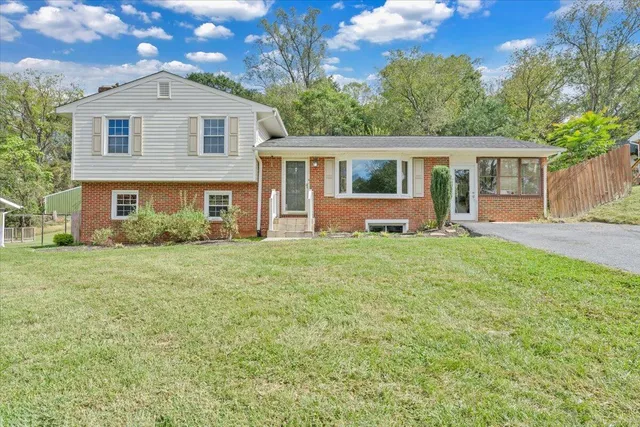 a front view of a house with a yard and trees