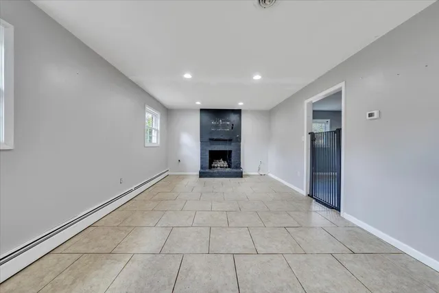 a view of an empty room with a fireplace and a window