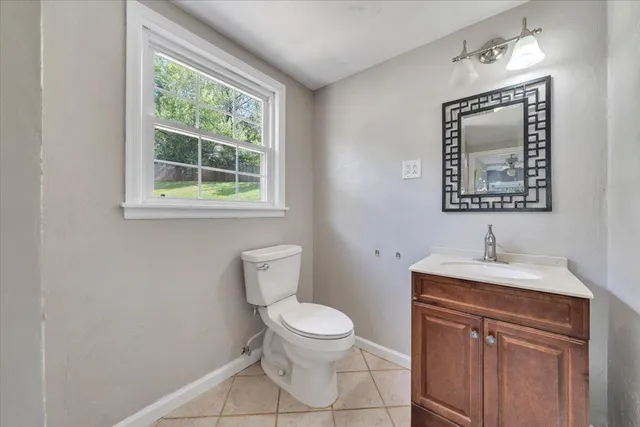 a bathroom with a toilet a sink and a mirror