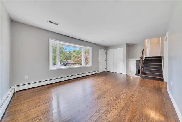 wooden floor in an empty room with a window