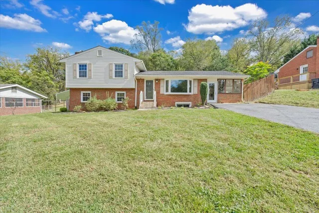 a view of a house with backyard and a tree