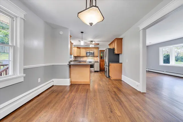 a view of a kitchen with wooden floor and a window