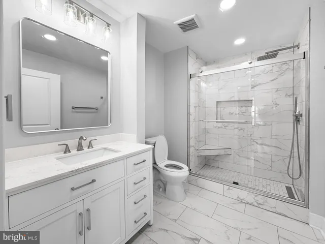 a bathroom with a double vanity sink toilet and shower