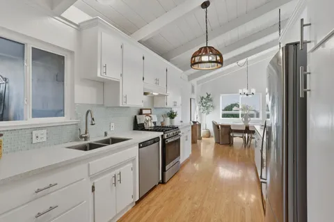 a kitchen with a white cabinets and chandelier