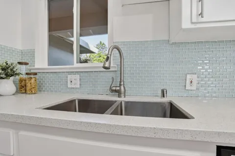 a kitchen with stainless steel appliances kitchen island granite countertop a stove a sink and a refrigerator