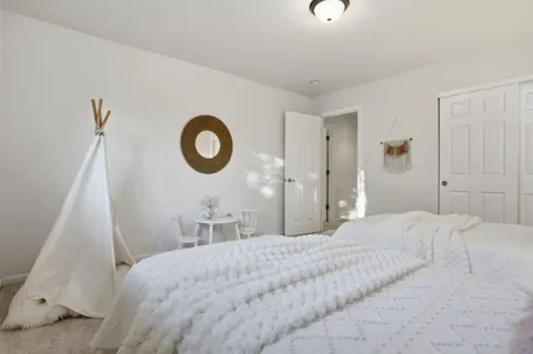 a bedroom with a bed a mirror and a large window