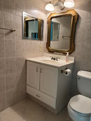a bathroom with a toilet sink and mirror