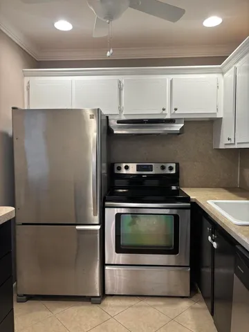 a kitchen with stainless steel appliances granite countertop a refrigerator a stove a sink and a microwave