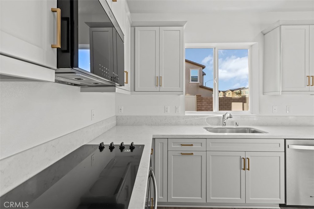 9667 Salamanca Street Riverside, CA 92508 - Photo 5 of 15 a kitchen with a sink cabinets and a stove