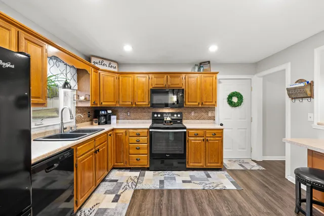 a kitchen with stainless steel appliances granite countertop a stove a sink and a refrigerator