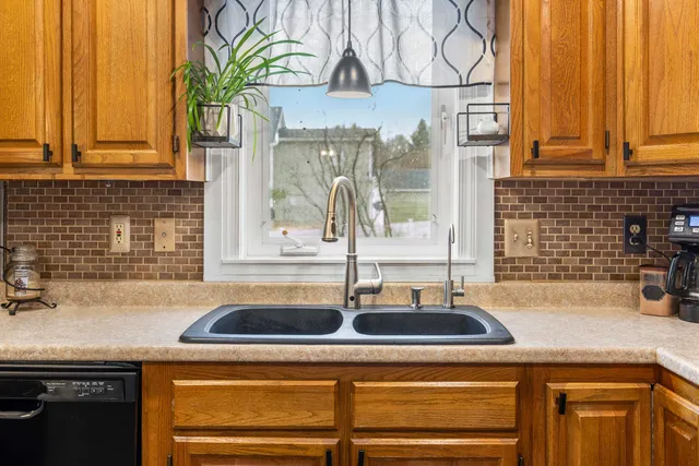 a kitchen with stainless steel appliances granite countertop a stove a sink dishwasher and a refrigerator with wooden floor