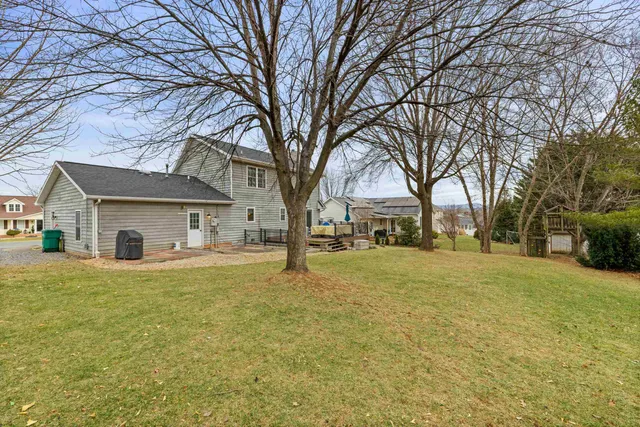 a view of a house with a yard covered with snow and trees
