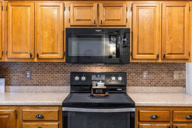 a kitchen with stainless steel appliances granite countertop a refrigerator stove top oven and sink