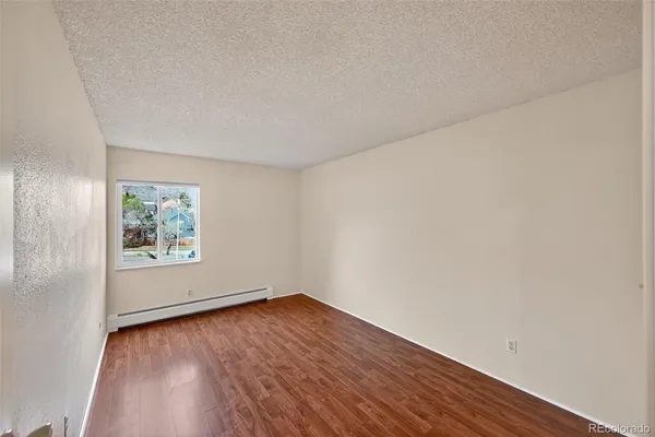 an empty room with wooden floor and window