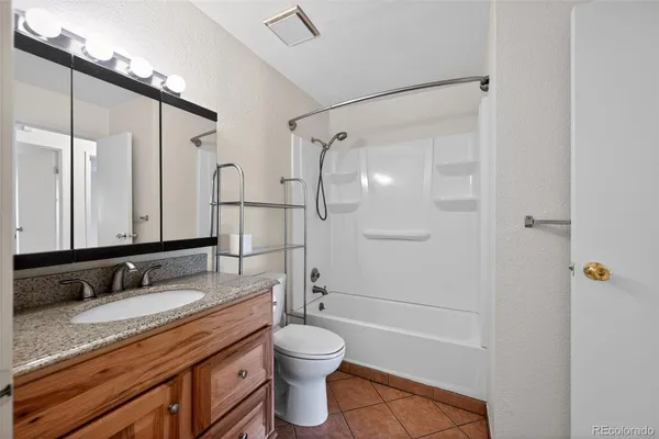 a bathroom with a granite countertop sink toilet and shower