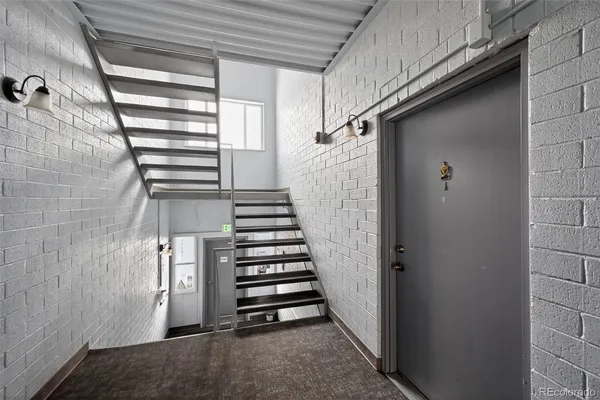 a view of a hallway with stairs and a window