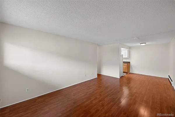 a view of empty room with wooden floor