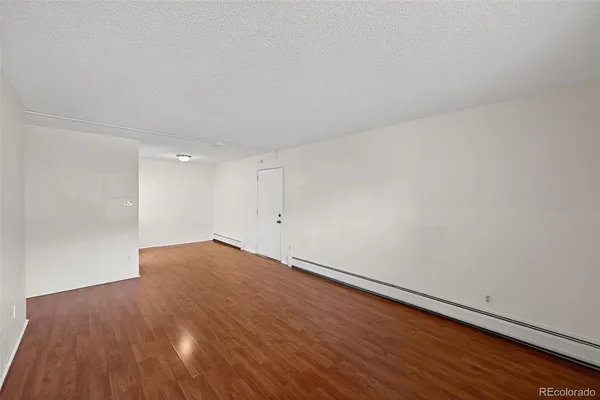 a view of empty room with wooden floor