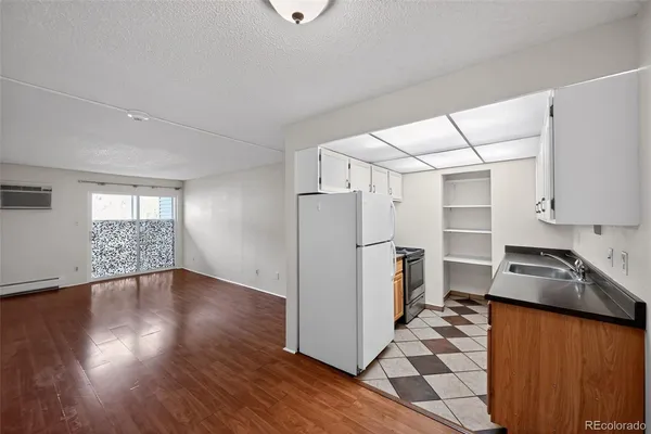 a kitchen with granite countertop a refrigerator and a stove top oven
