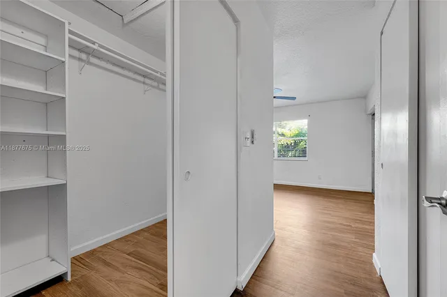 a view of an empty room with closet and a window