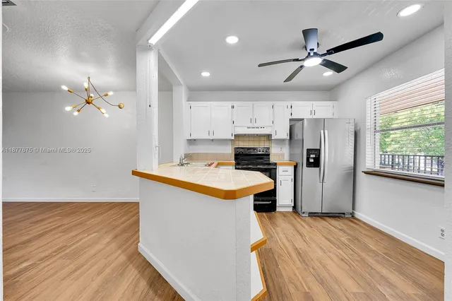 a kitchen with kitchen island a sink appliances and cabinets