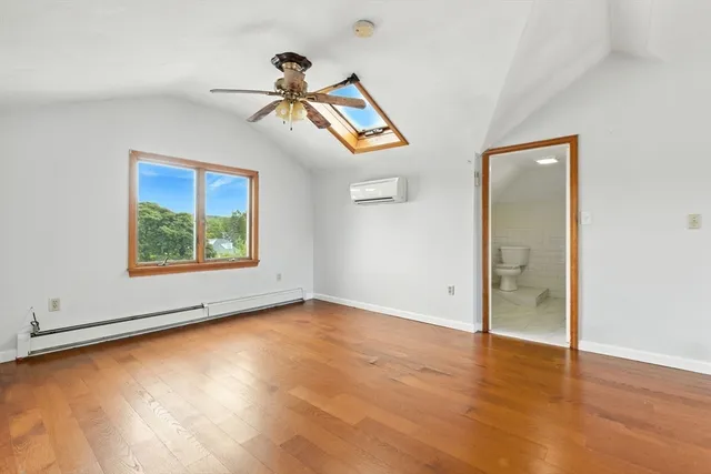 an empty room with wooden floor chandelier and windows