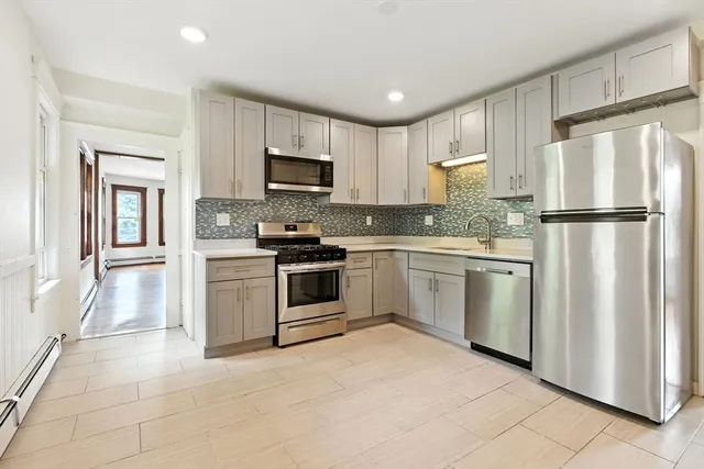 a kitchen with white cabinets and white appliances