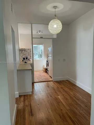 a view of a room with wooden floor mirror and windows