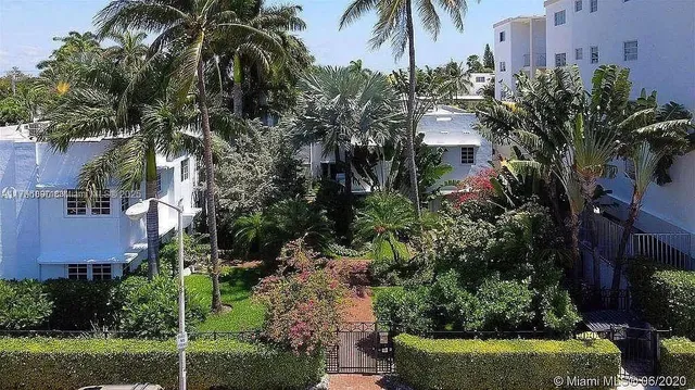 a view of a house with a yard and potted plants
