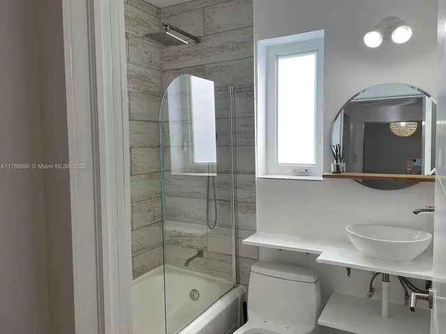 a bathroom with a sink a toilet and shower