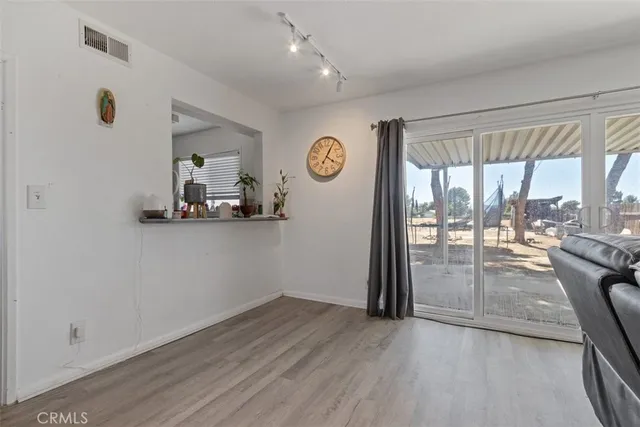 a view of a livingroom with wooden floor and furniture