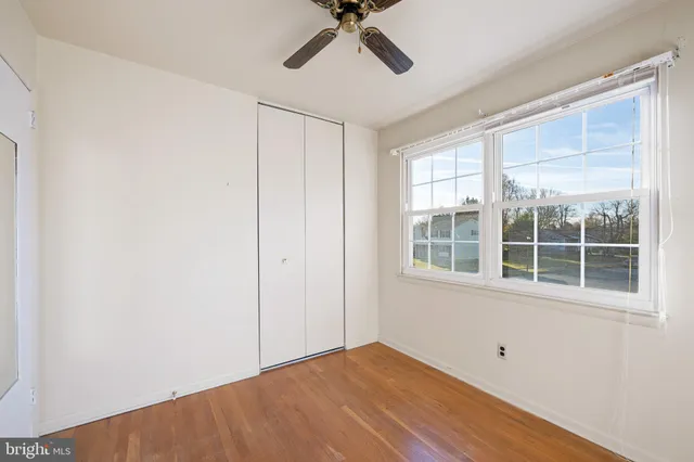 a view of empty room with wooden floor and windows