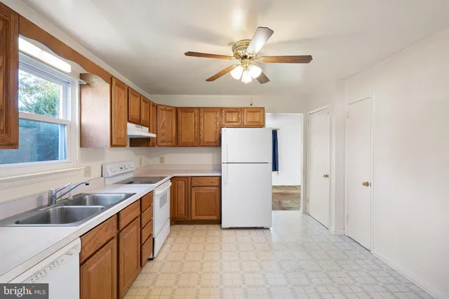 a kitchen with sink a refrigerator and cabinets