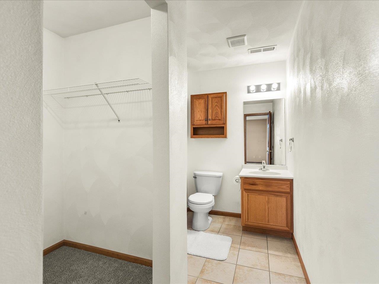 10184 Metalmark Lane Roscoe, IL 61073 - Photo 21 of 29 a bathroom with a toilet a sink a mirror and vanity