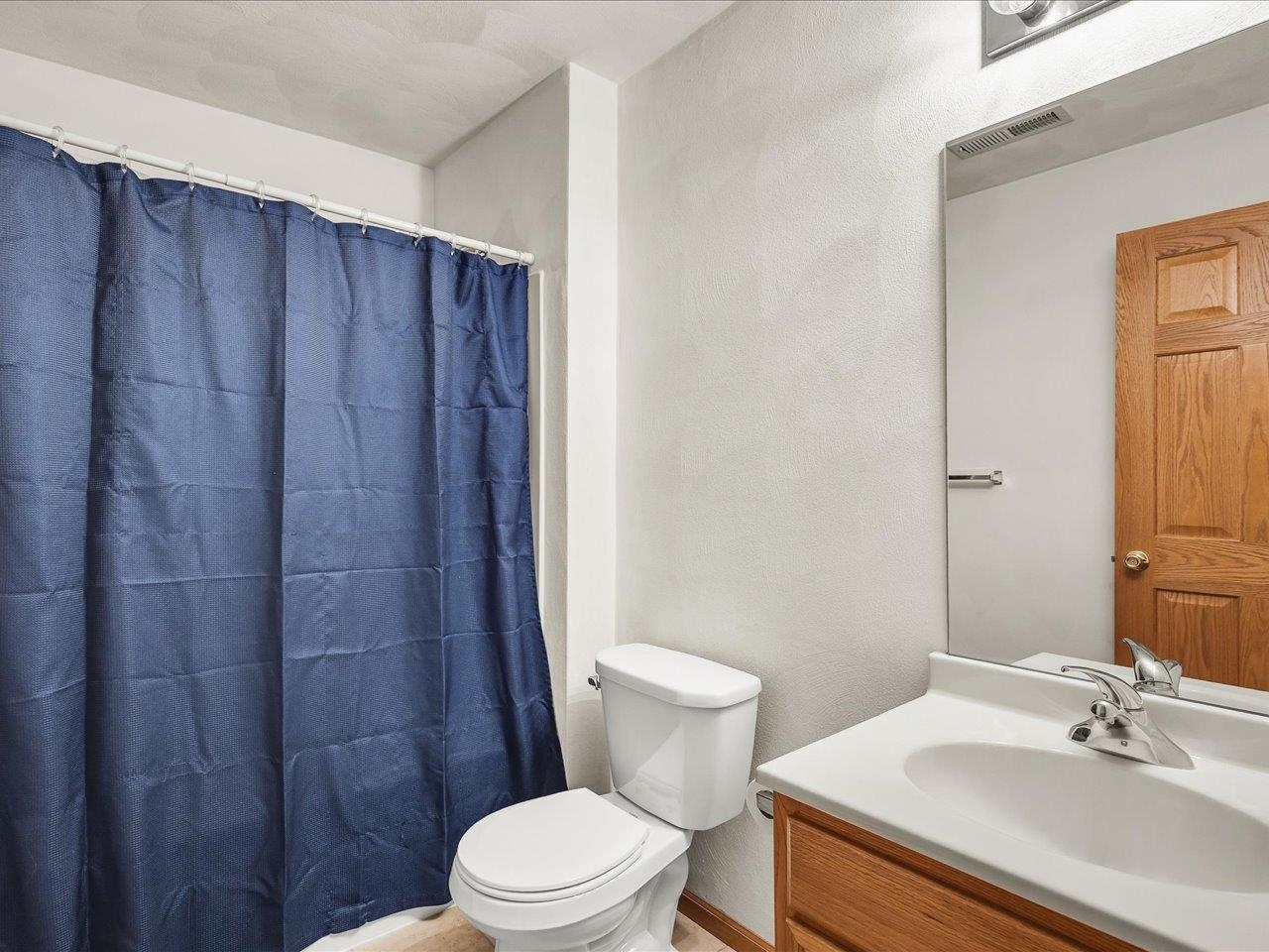 10184 Metalmark Lane Roscoe, IL 61073 - Photo 26 of 29 a bathroom with a sink a toilet a mirror and shower curtain