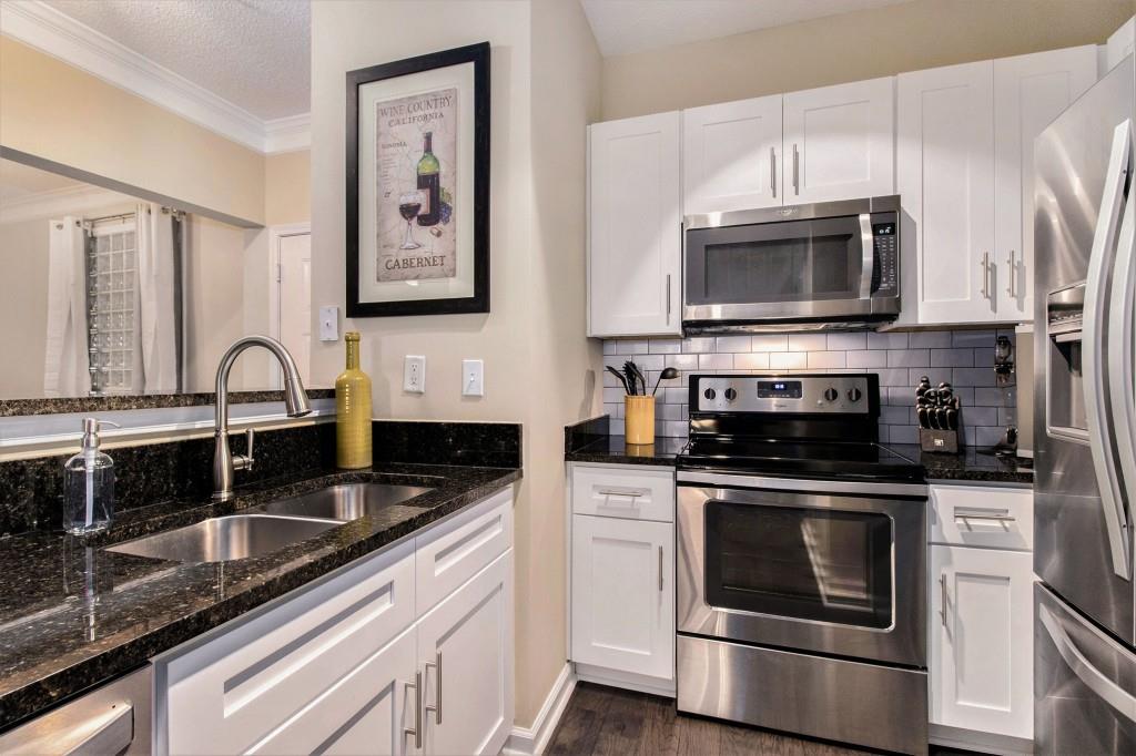 10 Perimeter Summit Boulevard, Unit 2112 Atlanta, GA 30319 - Photo 3 of 40 a kitchen with stainless steel appliances granite countertop a sink stove and microwave