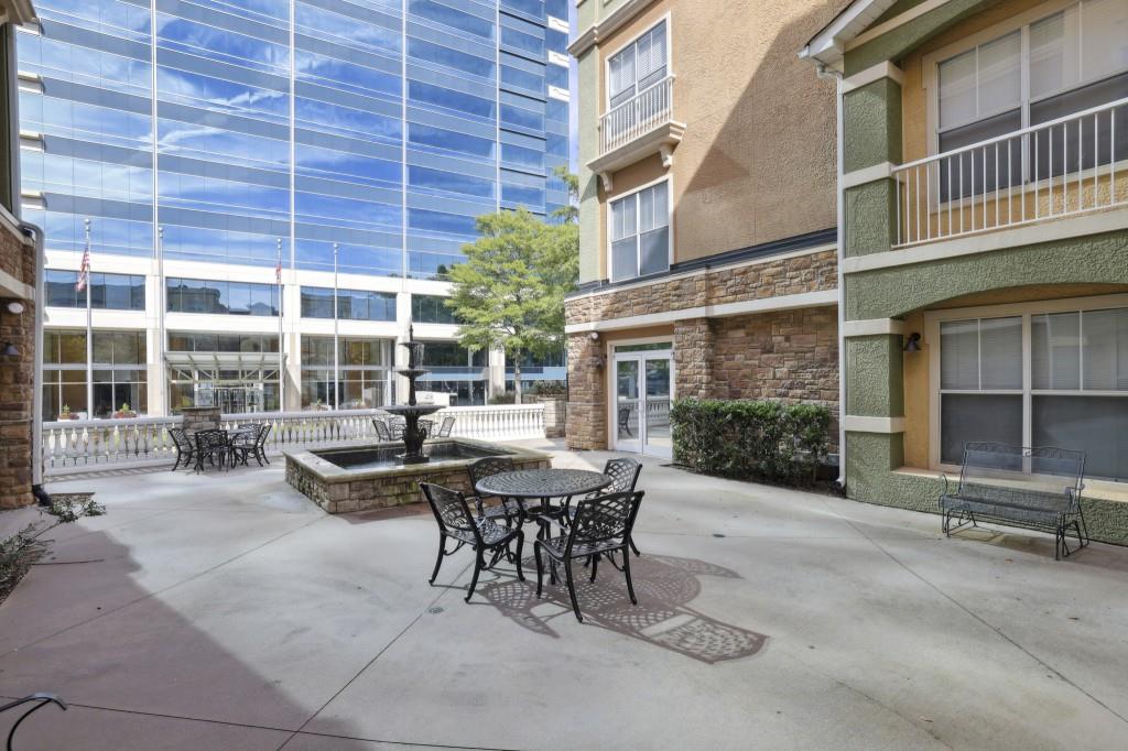 10 Perimeter Summit Boulevard, Unit 2112 Atlanta, GA 30319 - Photo 31 of 40 a view of a patio with a table and chairs and floor to ceiling window